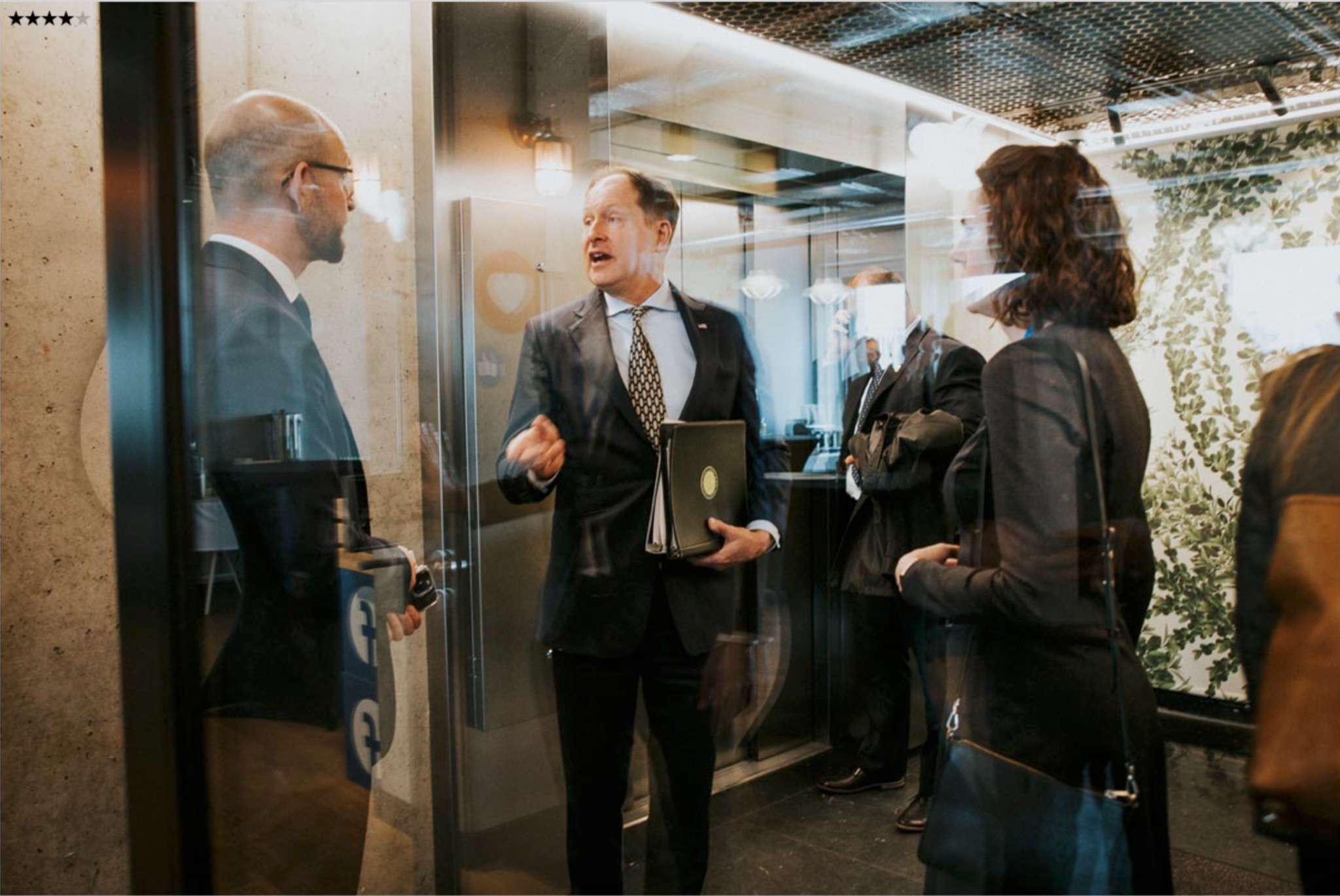 Executive backstage conversation in glass corridor